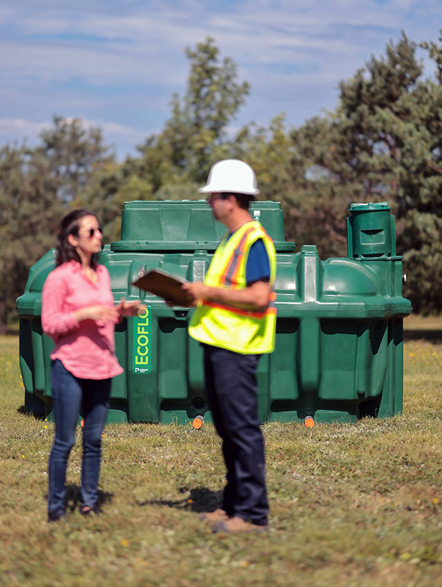 Homeowner and septic system installer standing in front of the polyethylene Ecoflo compact biofilter.